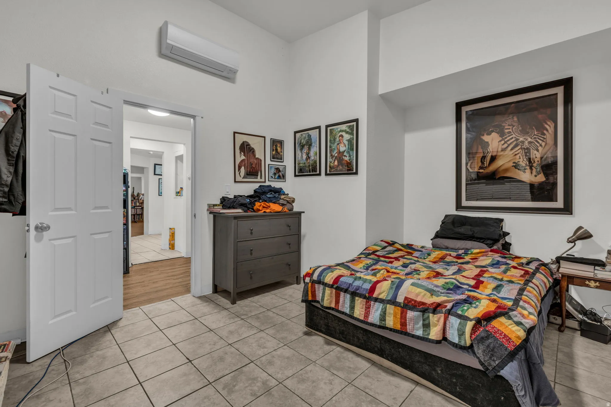Bedroom featuring light tile patterned floors and a wall mounted mini split