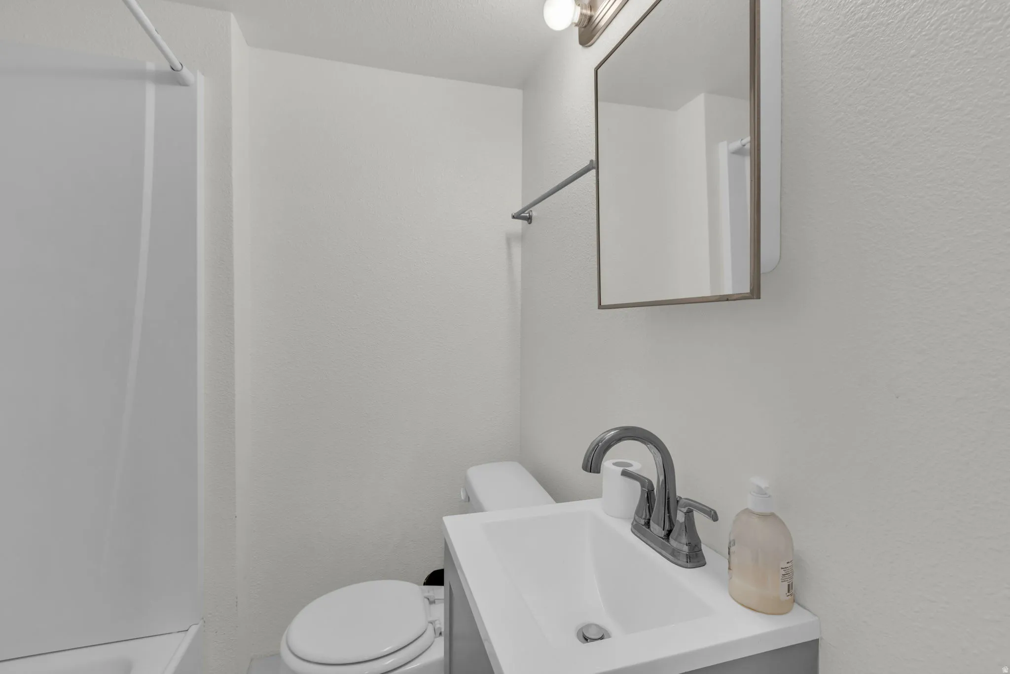 Bathroom with vanity and a textured wall