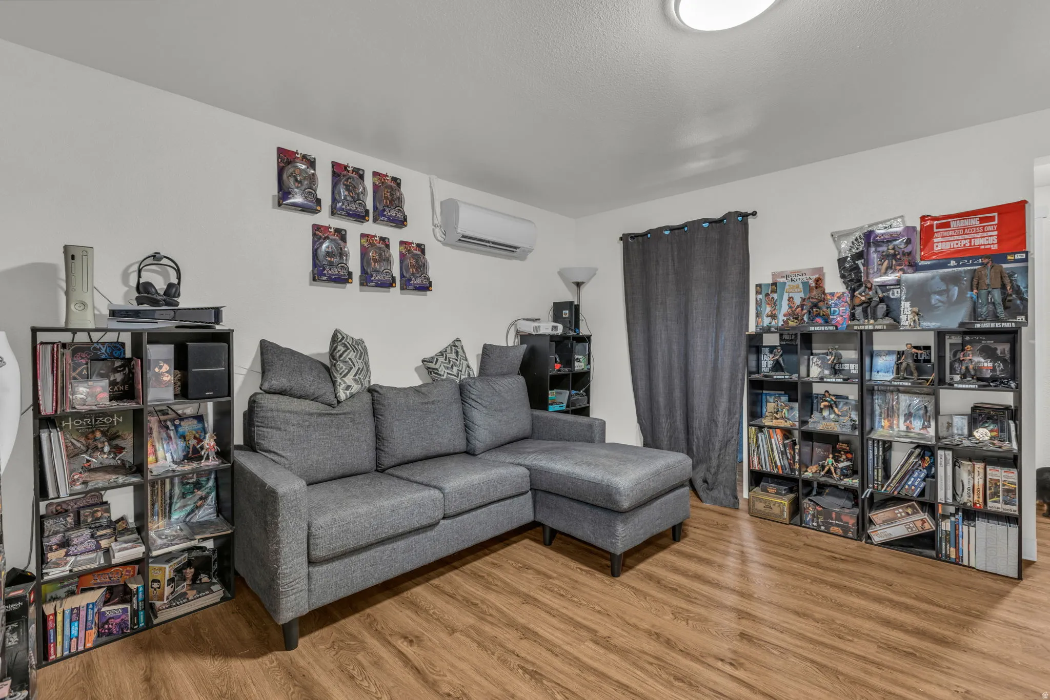 Living room with light wood-style floors and a wall mounted mini split
