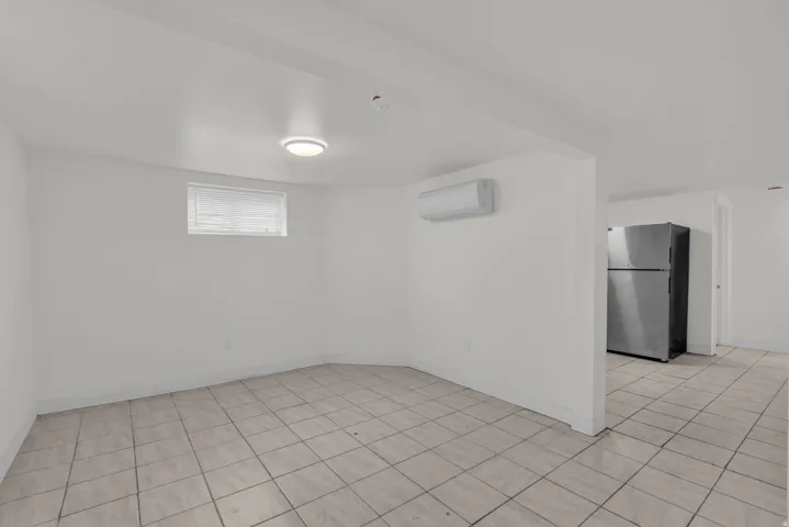 Empty room with light tile patterned flooring and baseboards
