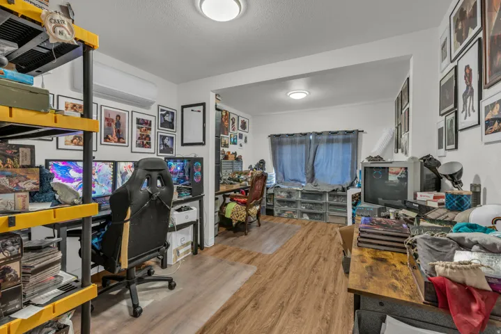 Office area featuring light wood-style floors, a mini split for heating / cooling, and a textured ceiling