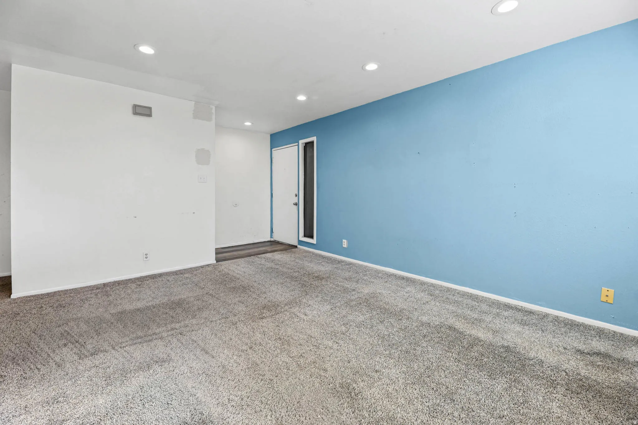 Unfurnished room with dark colored carpet and recessed lighting