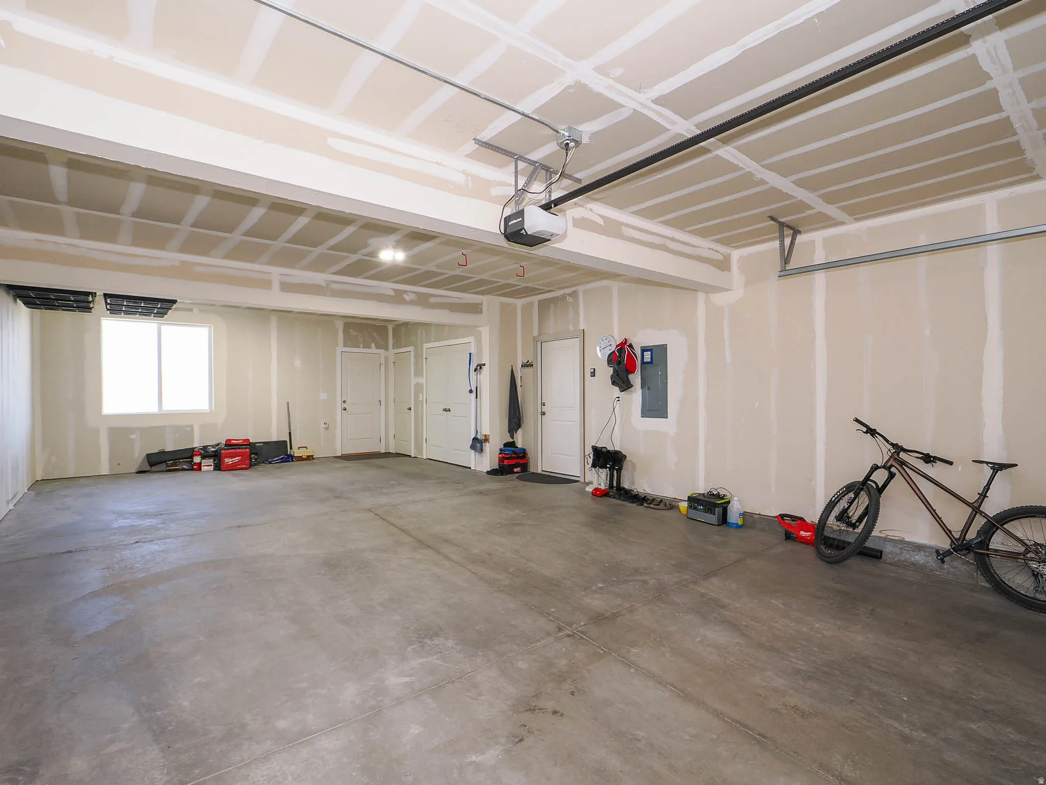 Garage featuring electric panel and a garage door opener