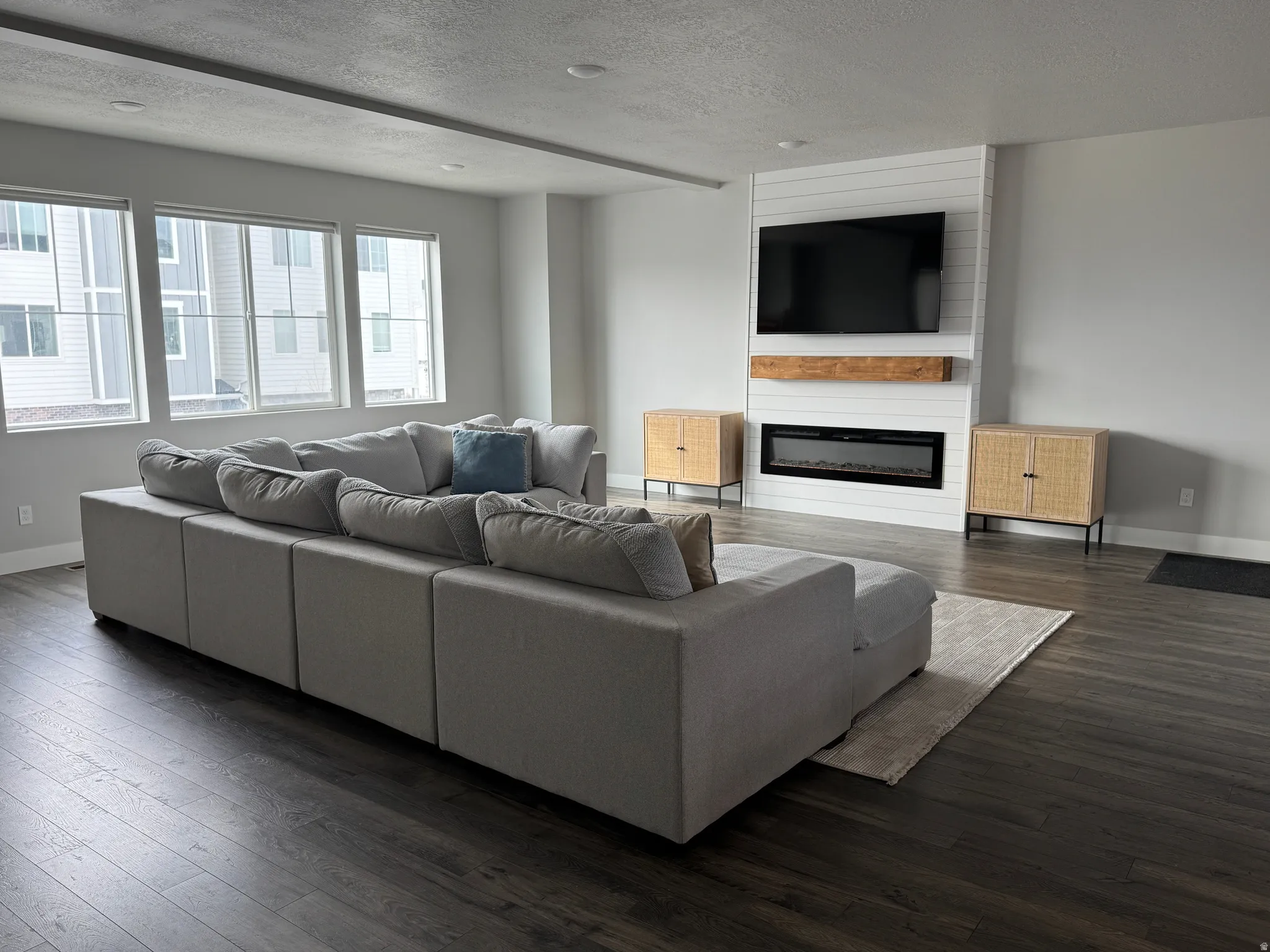 Living area with dark wood-style flooring, a fireplace, and a textured ceiling