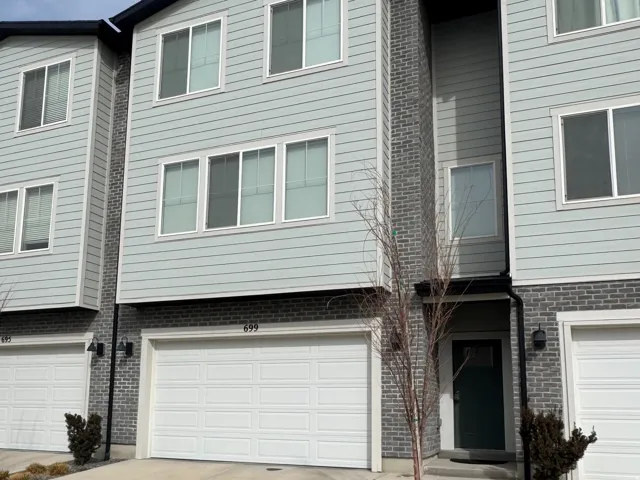 View of front facade with concrete driveway, a garage, and brick siding