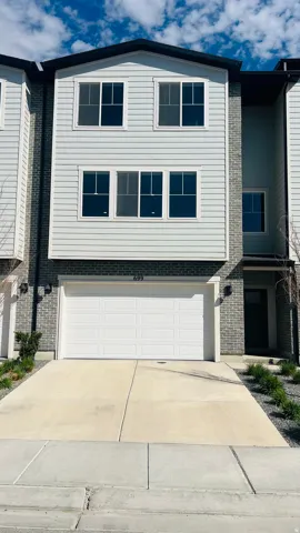 View of front of property with concrete driveway, a garage, and brick siding