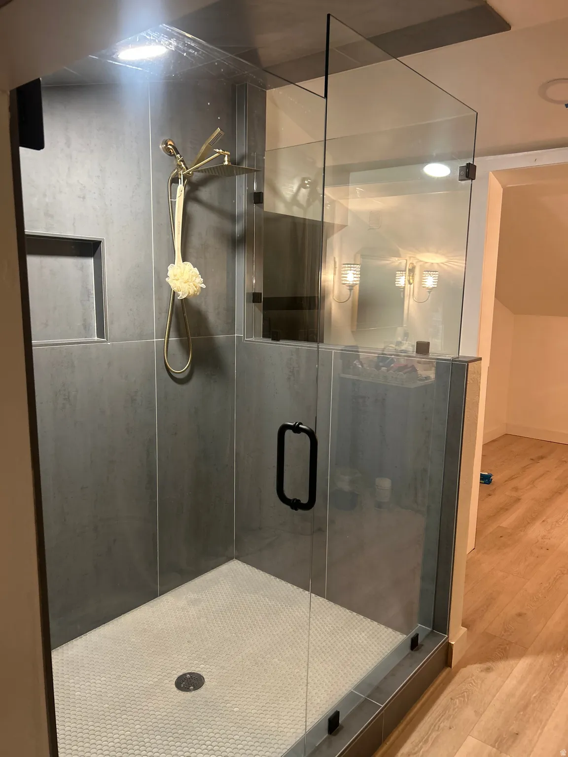 Bathroom with wood finished floors and a shower stall
