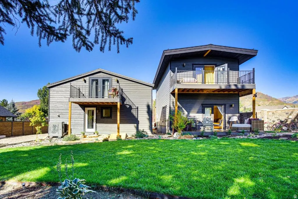Back of house with a balcony and a mountain view
