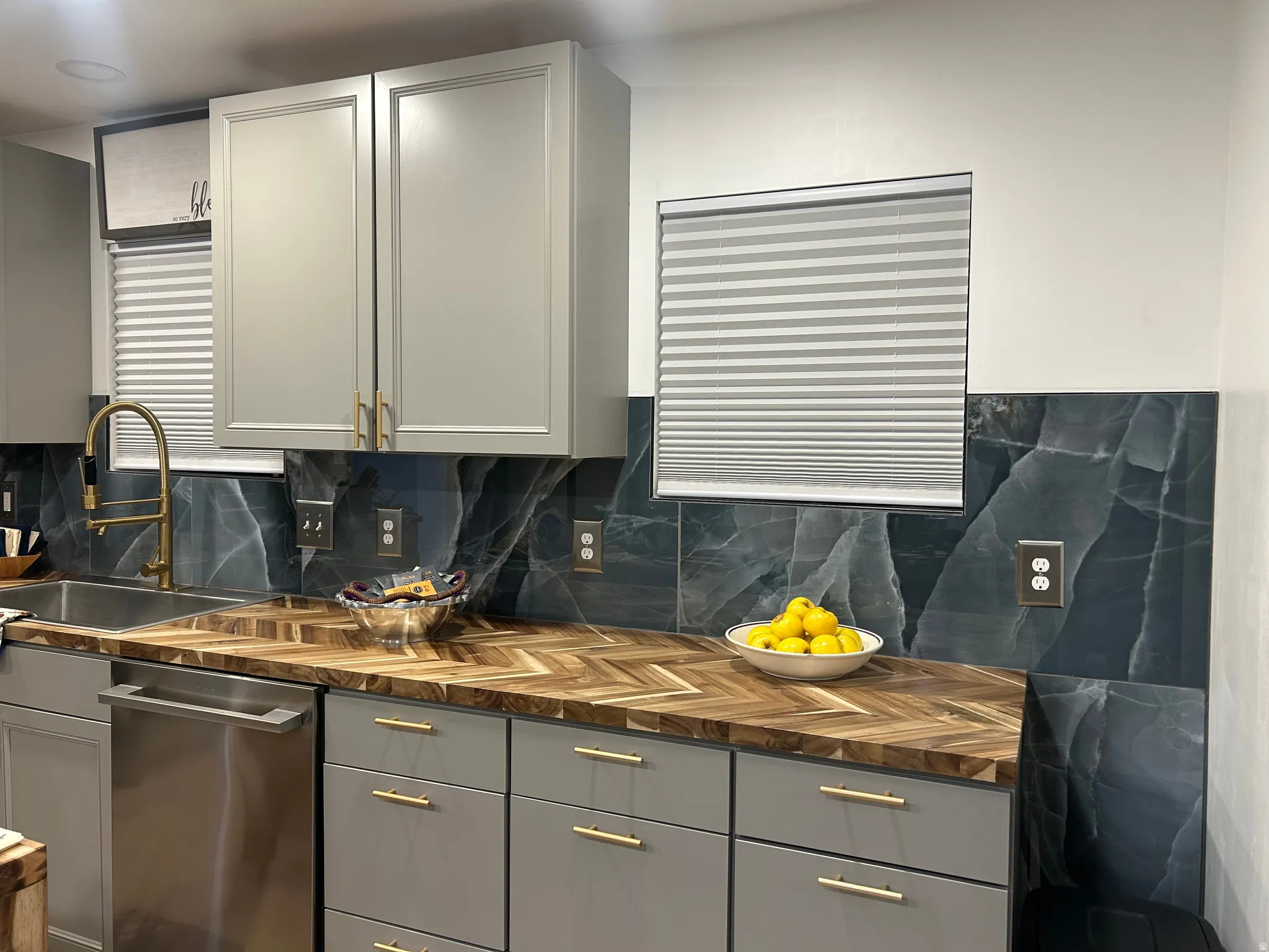 Kitchen featuring gray cabinetry, dishwasher, wooden counters, and decorative backsplash