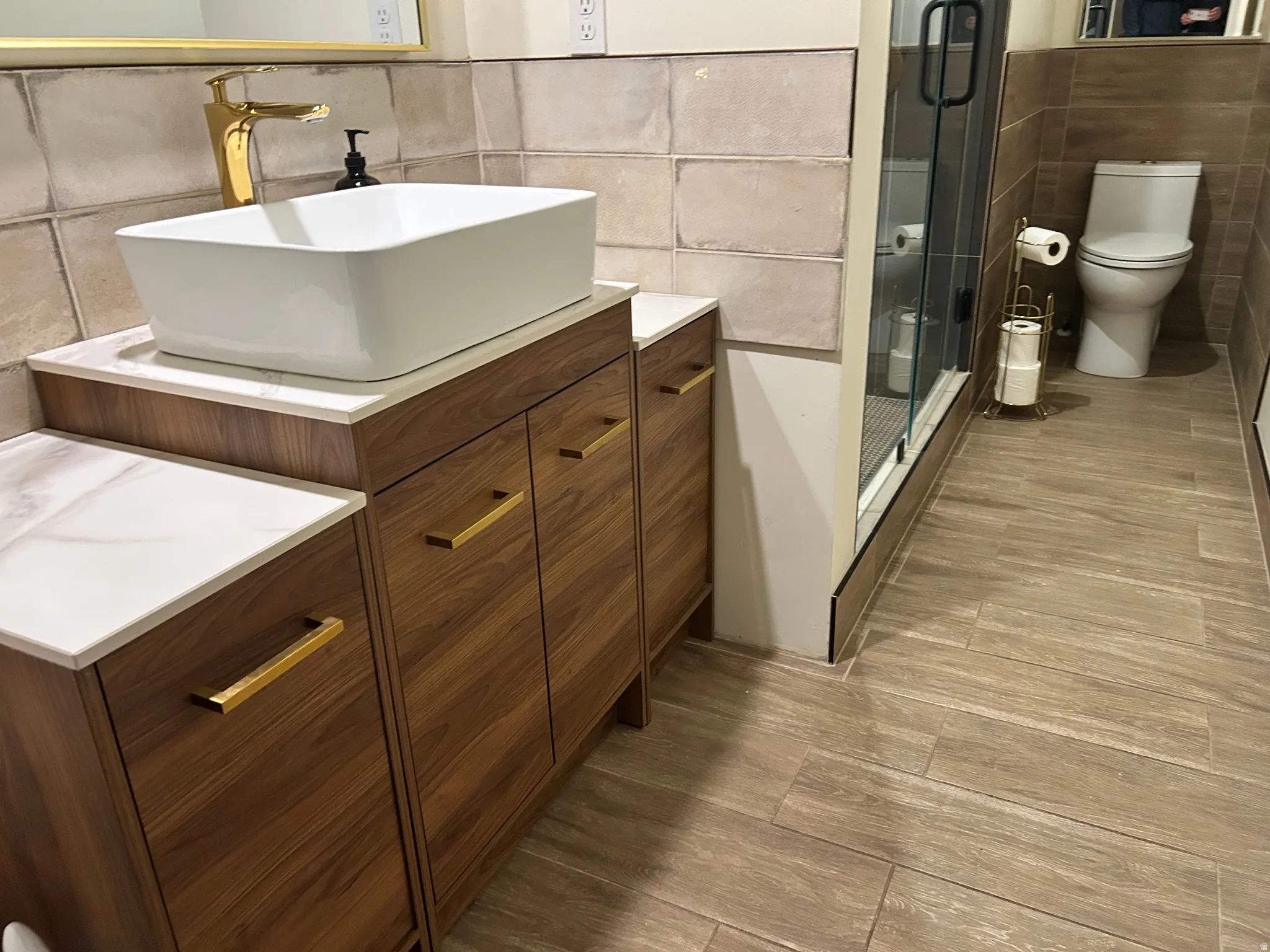 Full bath with tile walls, vanity, wood tiled floors, and a stall shower