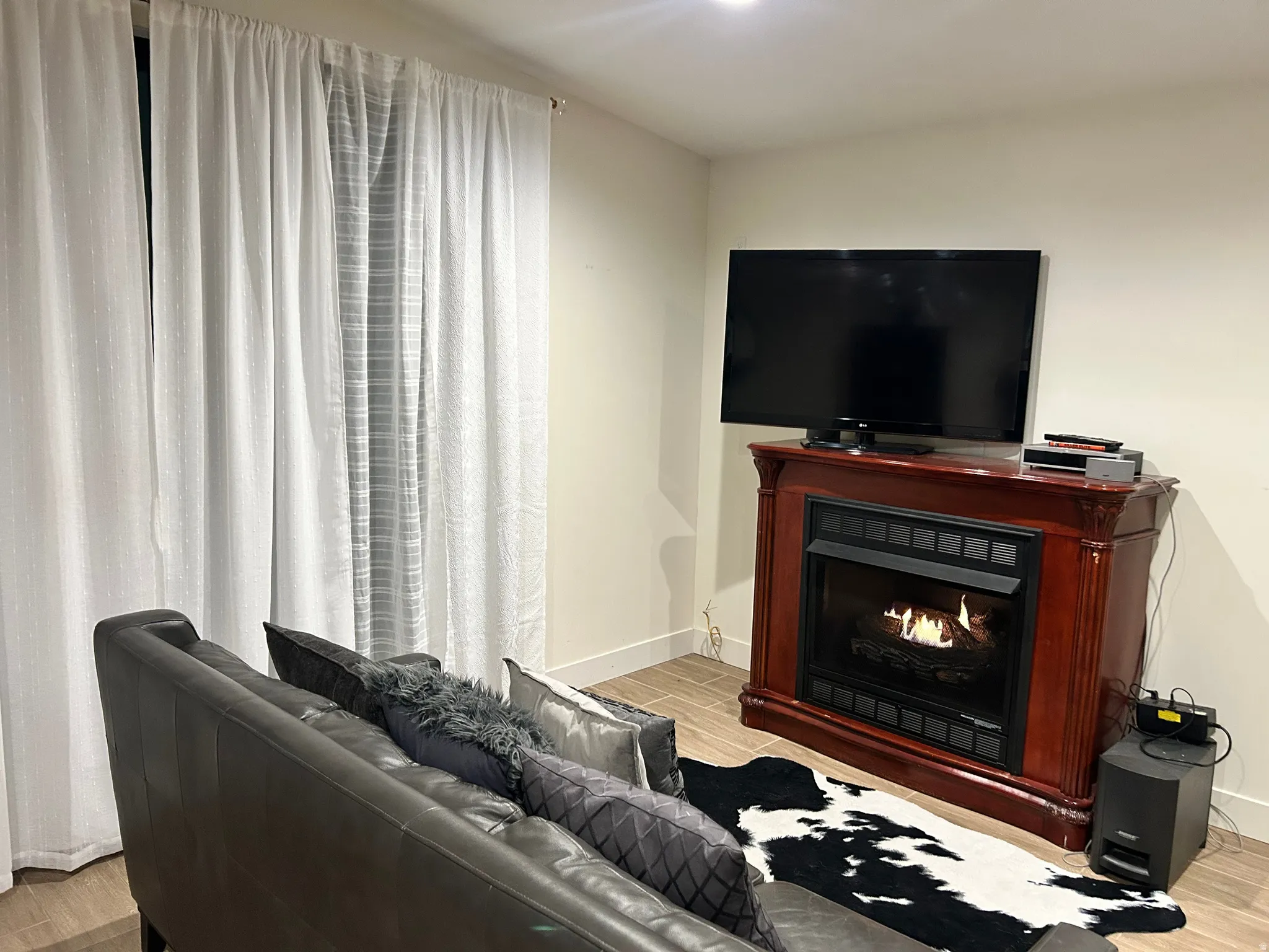 Living area featuring wood tiled floors and a lit fireplace