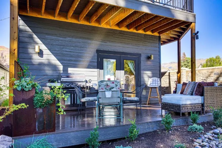 Deck with a grill, outdoor dining area, french doors, and a mountain view