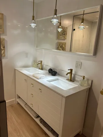 Bathroom featuring double vanity and light wood-style flooring