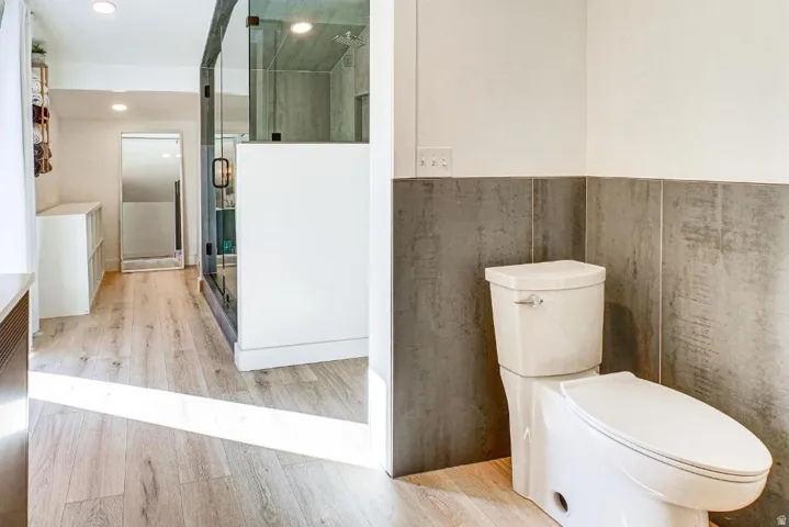Bathroom with light wood-type flooring, a stall shower, and recessed lighting