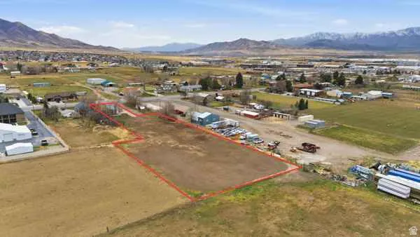 Aerial view of property and surrounding area featuring property parcel outlined and mountains