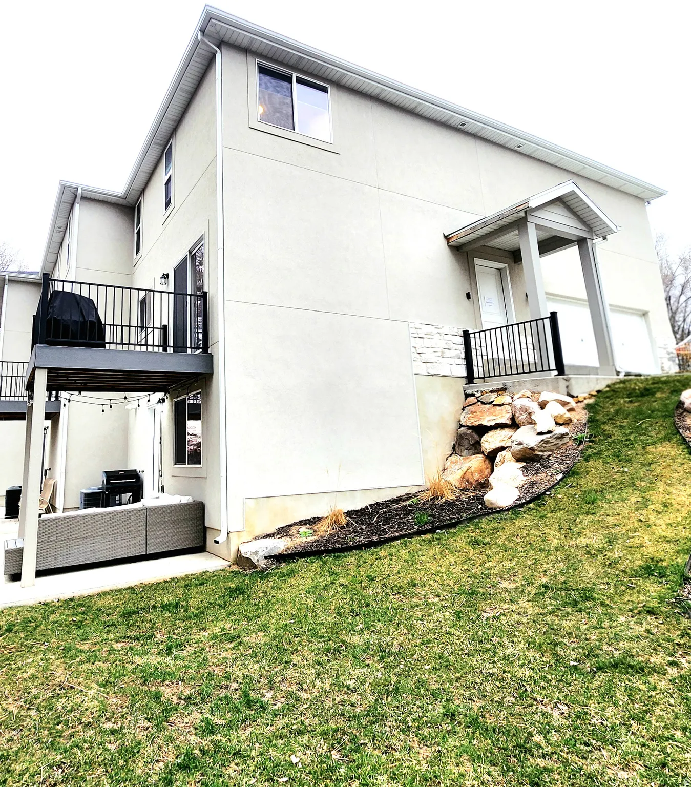 View of property exterior featuring a yard, outdoor lounge area, a patio, and stucco siding
