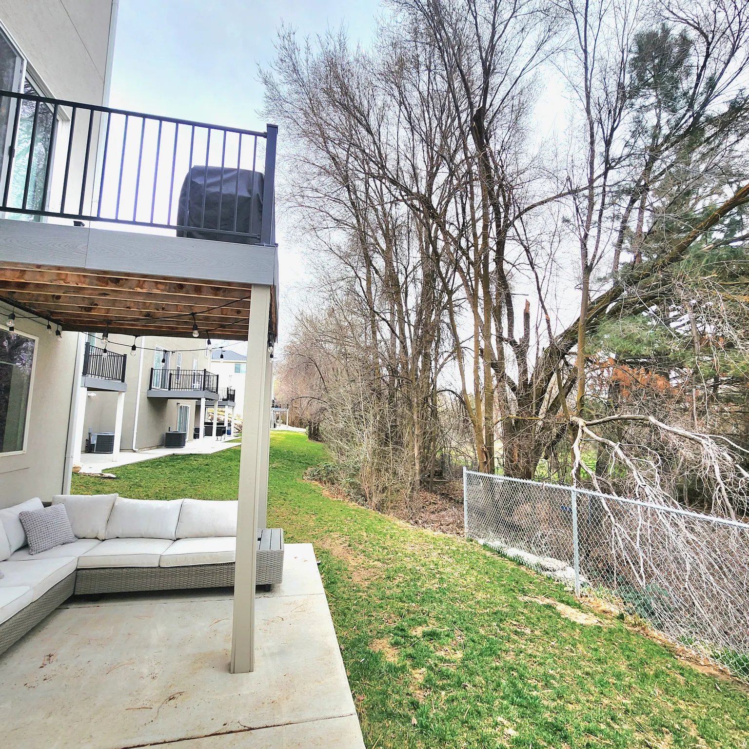 View of green lawn featuring an outdoor hangout area, a patio, and a balcony