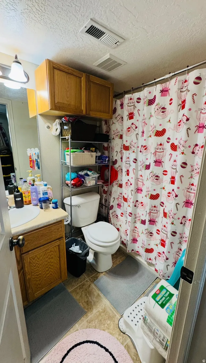Bathroom with vanity, a shower with shower curtain, and a textured ceiling