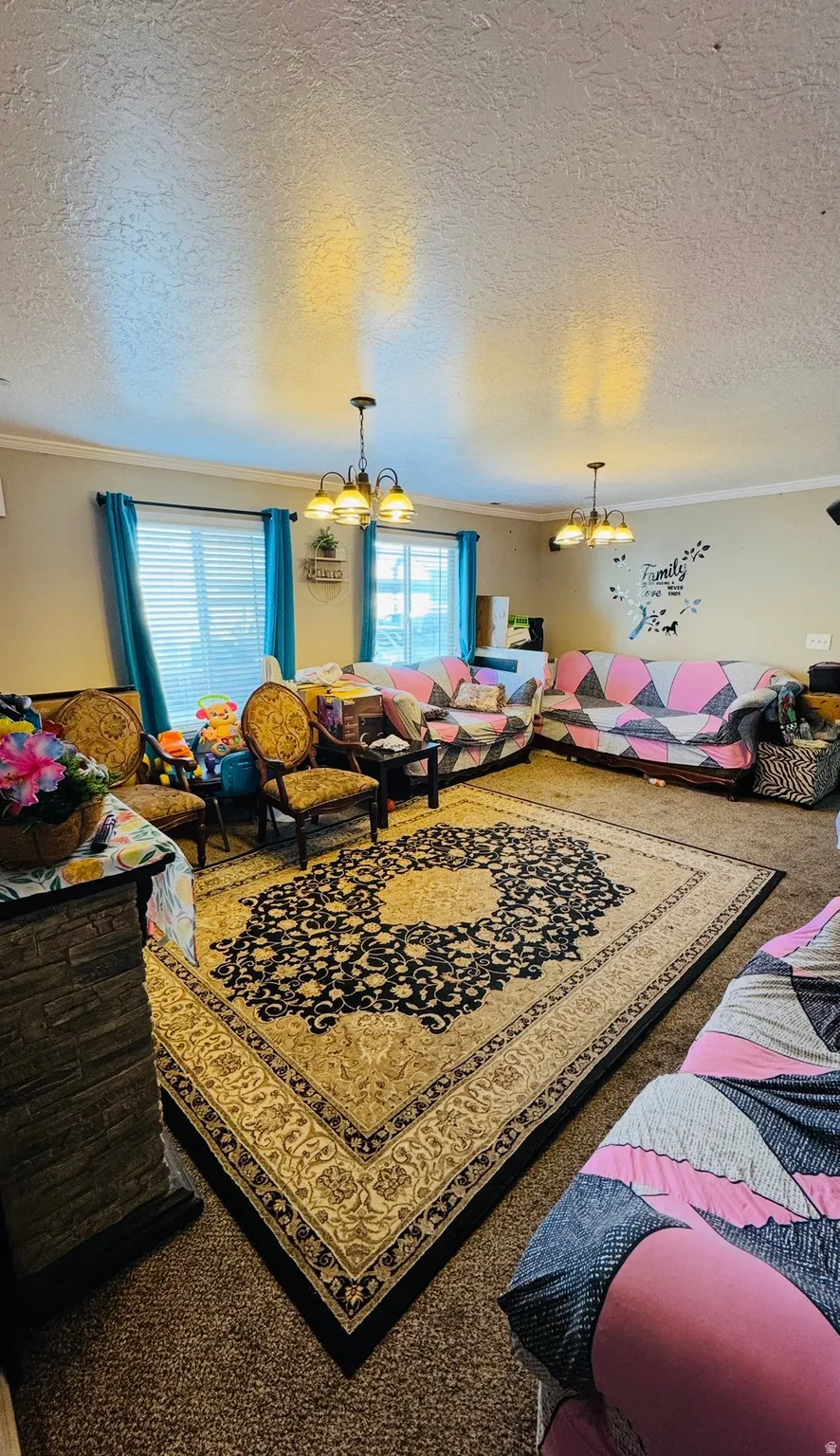 Playroom with suspended lighting, ornamental molding, a textured ceiling, and carpet flooring