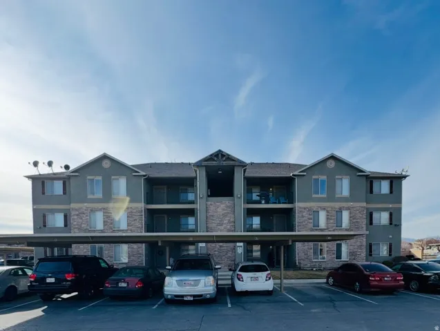 View of apartment building / complex with covered parking