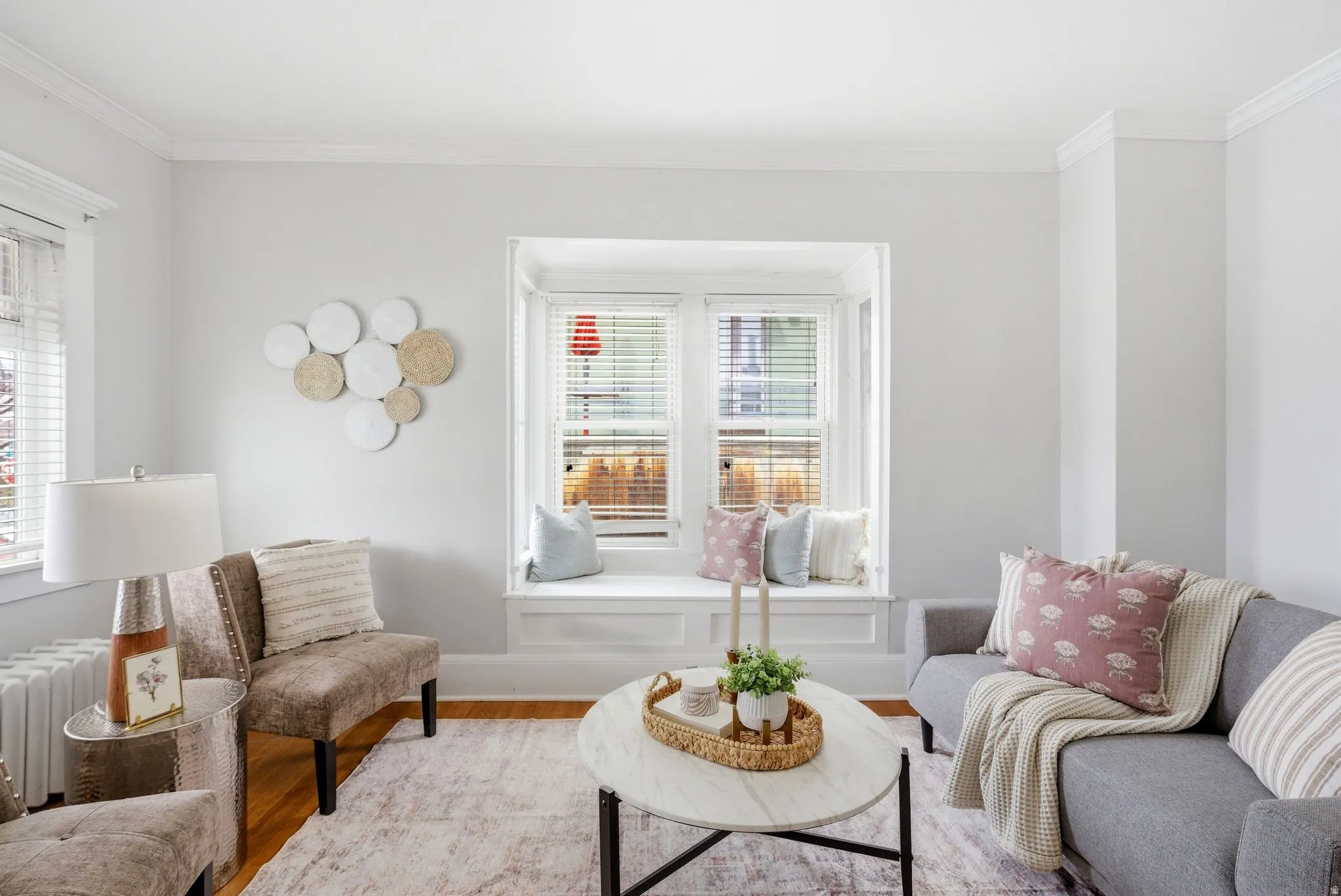 Sitting room featuring wood finished floors, radiator heating unit, and ornamental molding