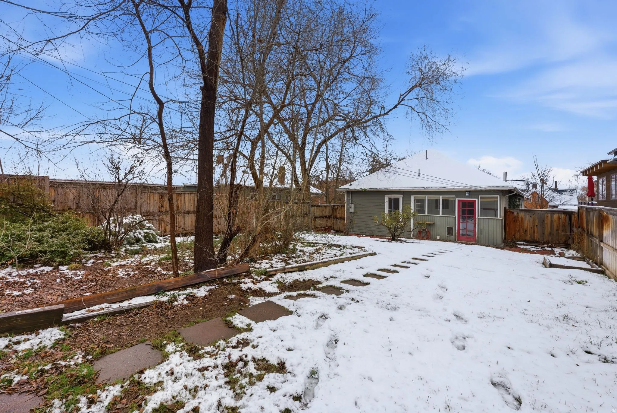 Snow covered property featuring a fenced backyard
