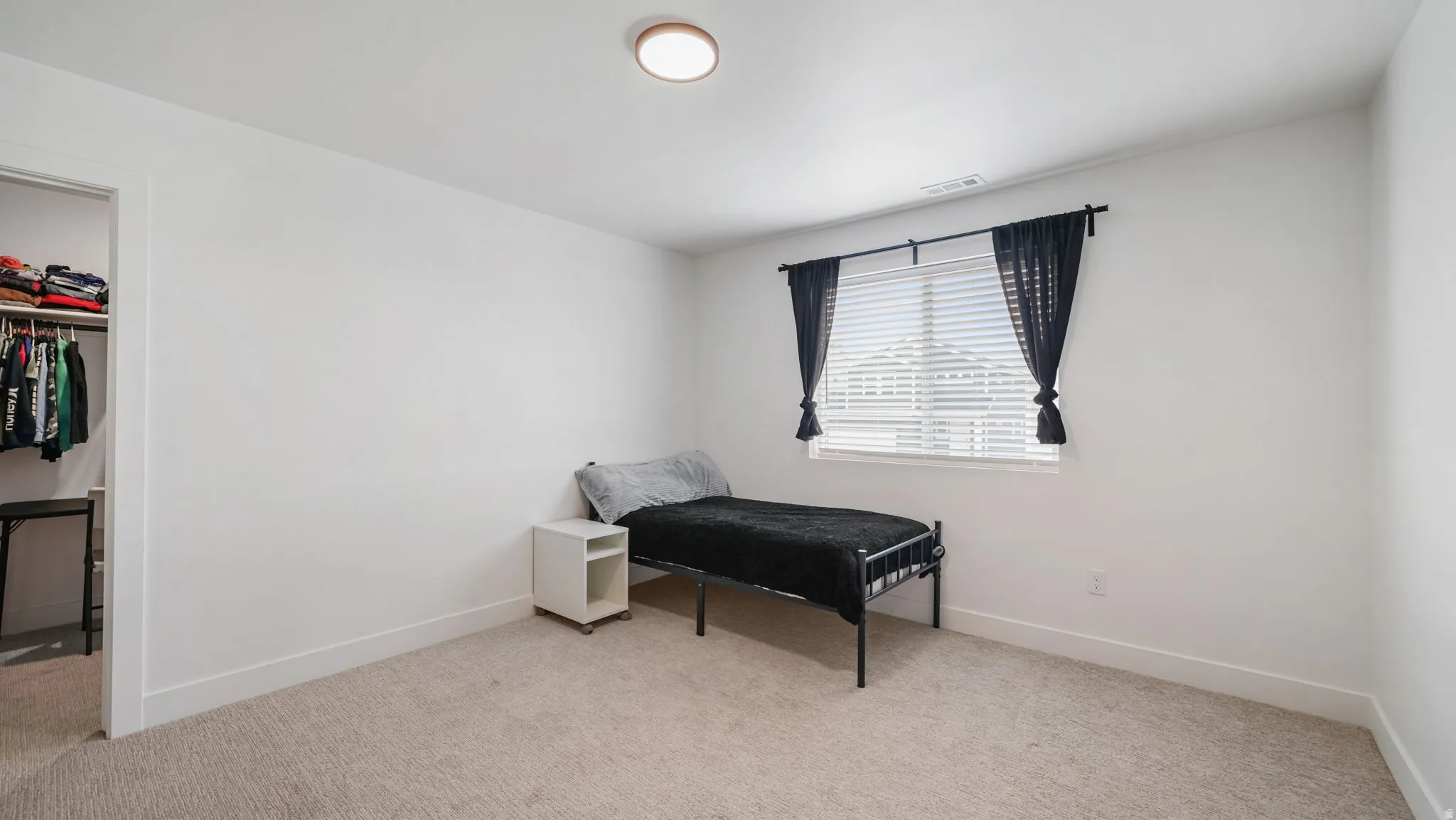 Living area with light colored carpet and baseboards