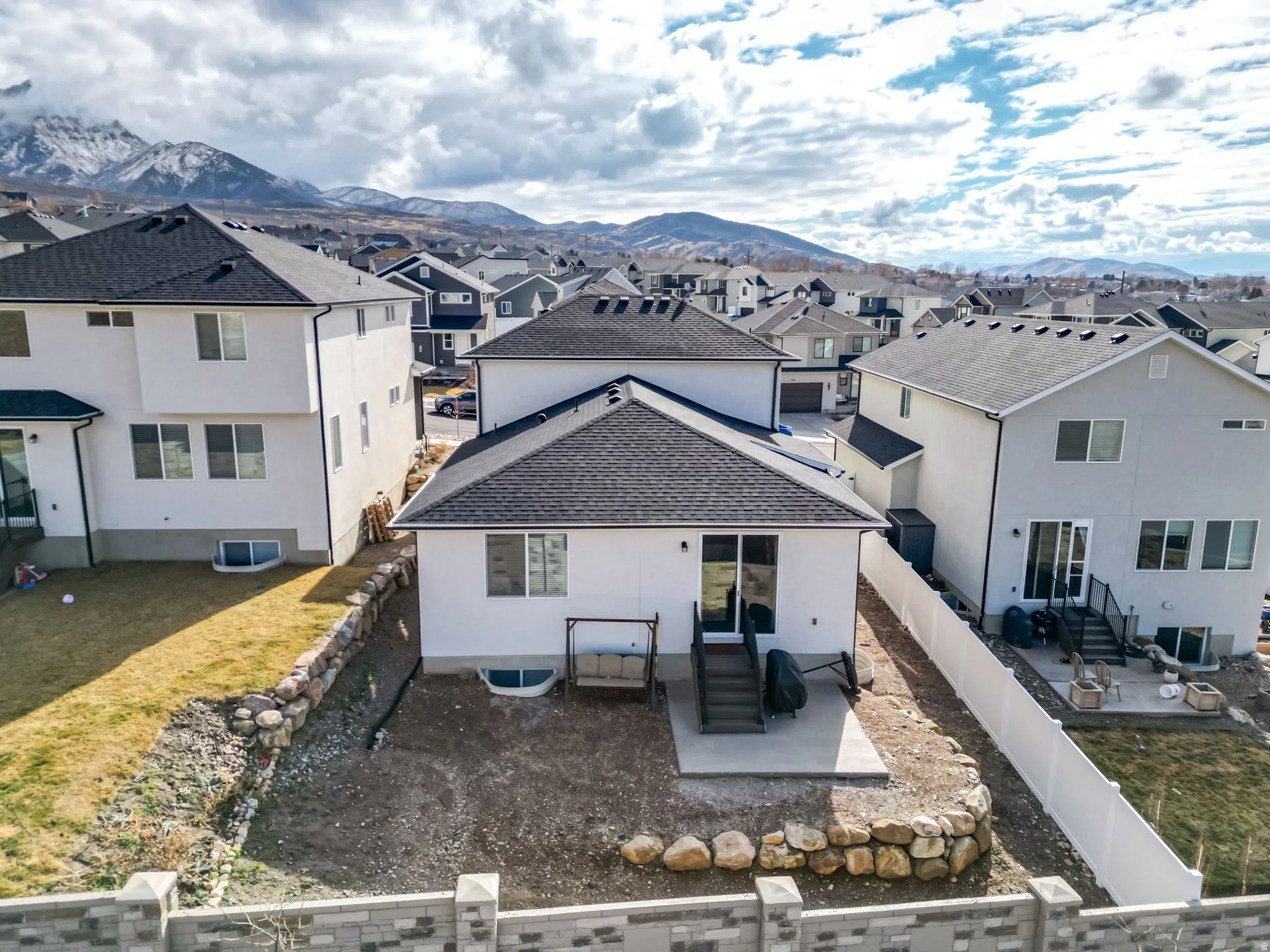 Back of property featuring a patio area, a residential view, a mountain view, and a fenced backyard