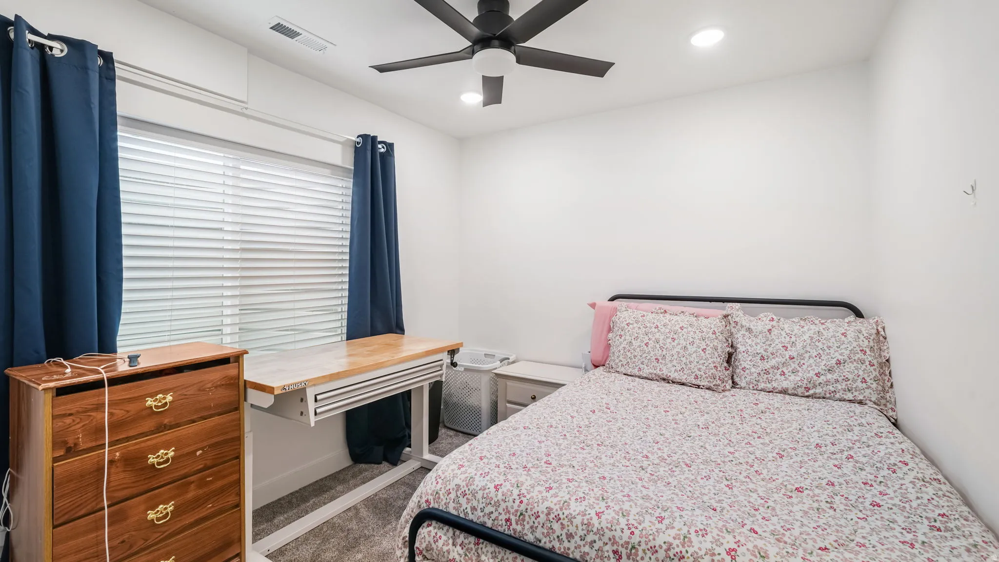 Carpeted bedroom with a ceiling fan and recessed lighting