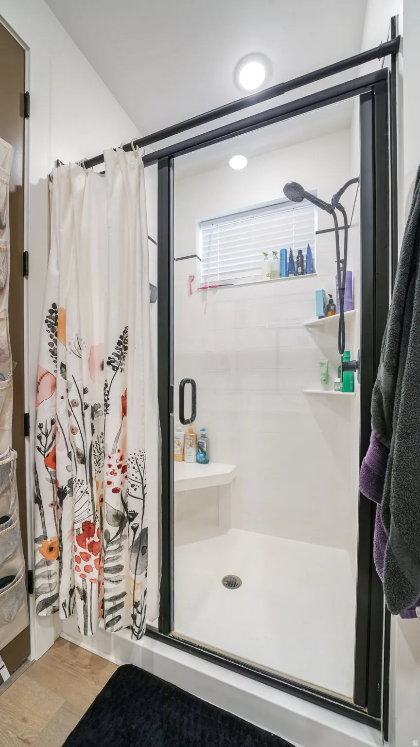 Bathroom featuring a stall shower and light wood-type flooring