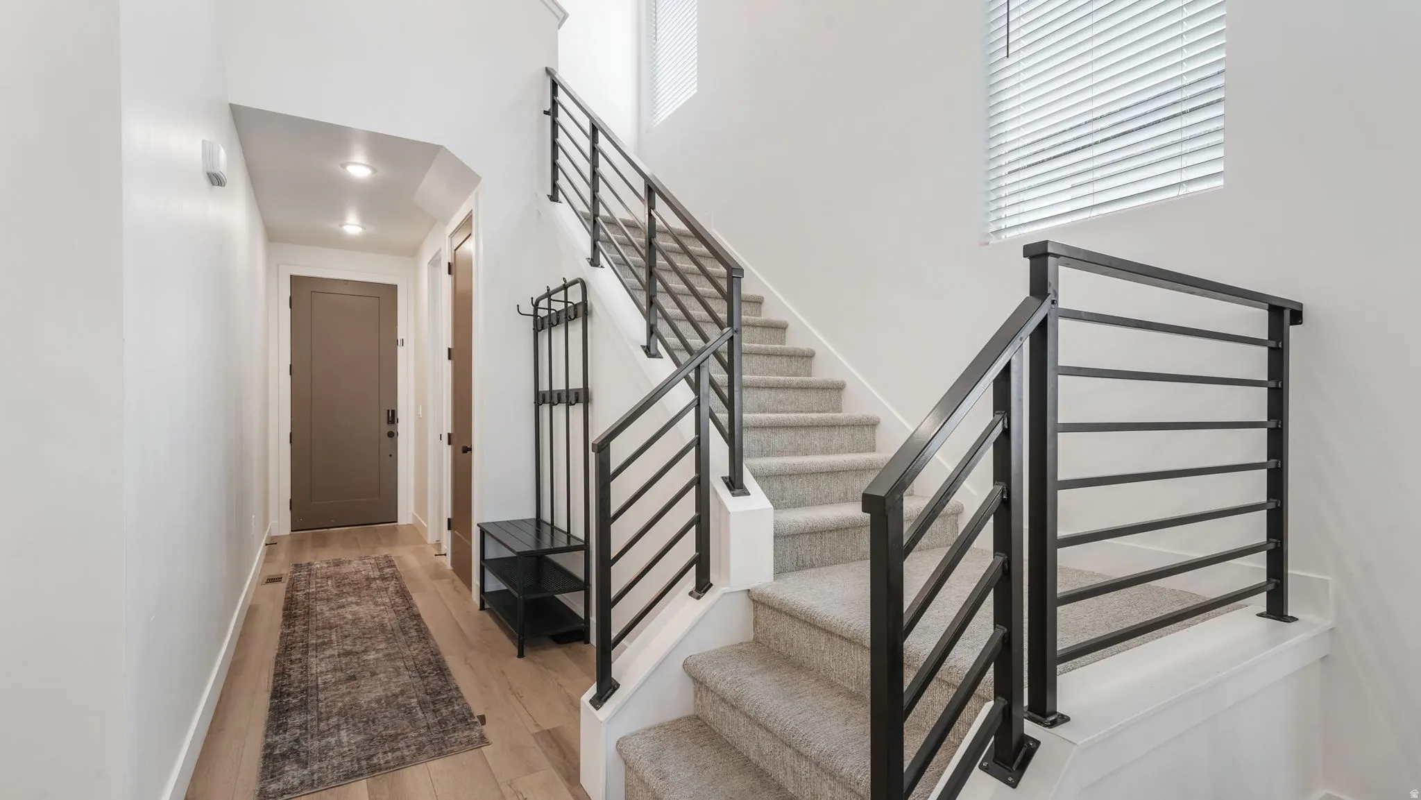 Stairway with a high ceiling and wood finished floors