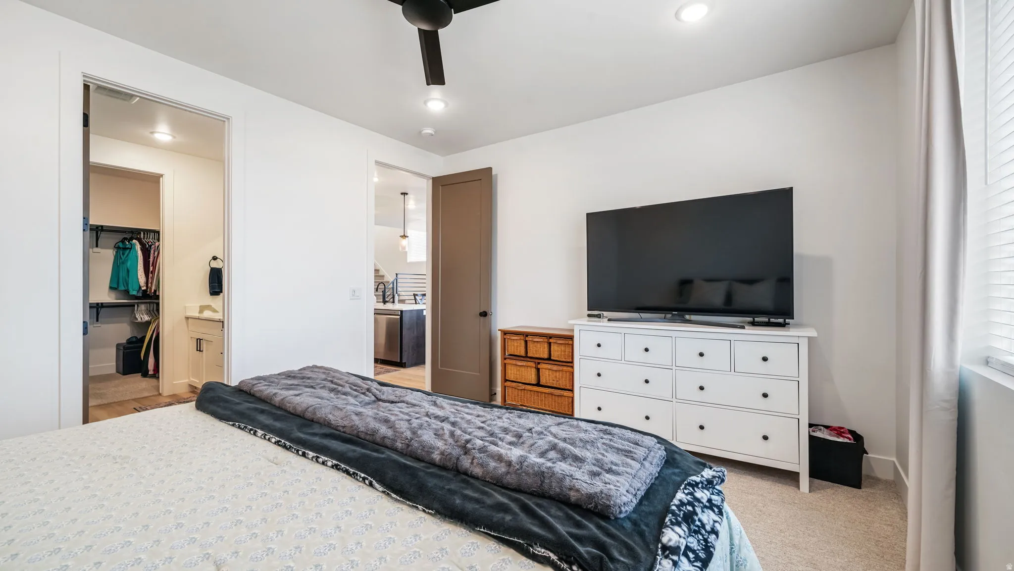 Bedroom with a walk in closet, a ceiling fan, light colored carpet, and recessed lighting