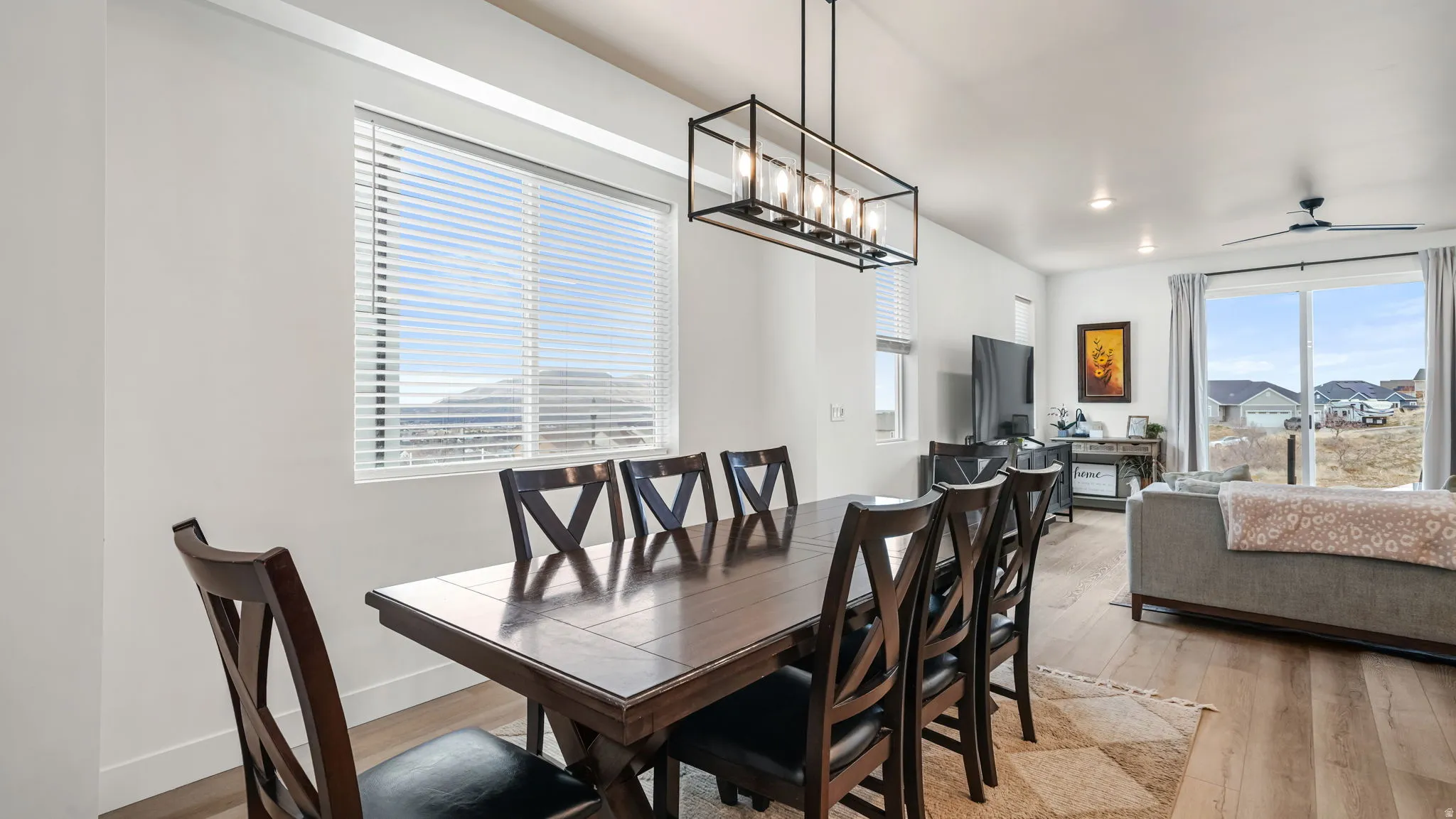 Dining room with light wood-type flooring, a chandelier, and a ceiling fan
