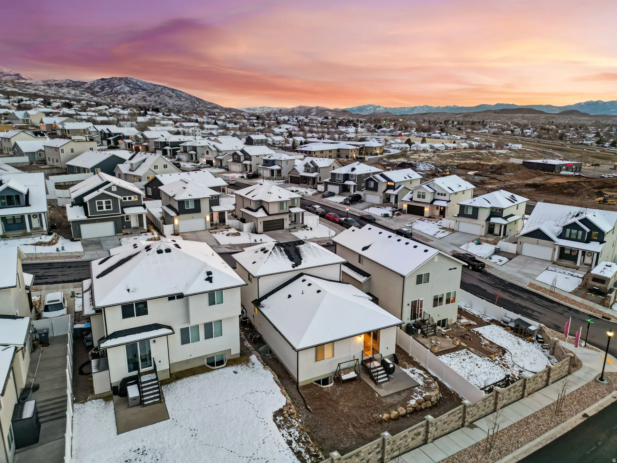 Snowy aerial view featuring a mountain view and a residential view