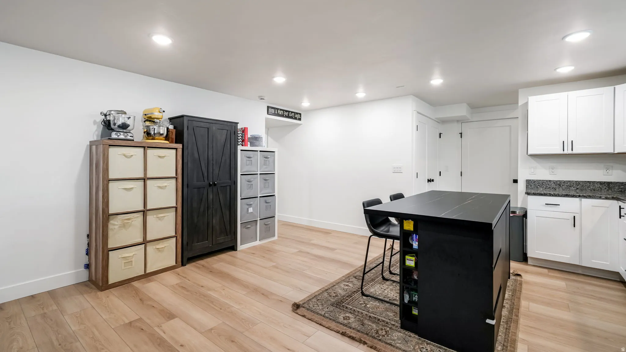 Kitchen with light wood-type flooring, recessed lighting, and white cabinetry