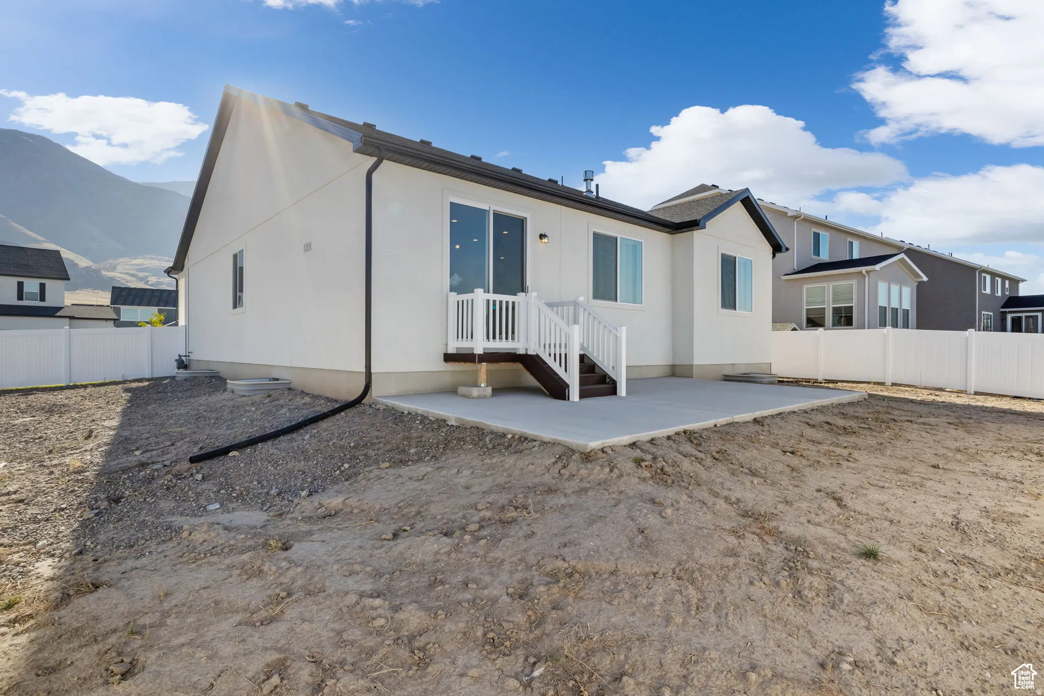 Rear view of house with a patio, a mountain view, and stucco siding