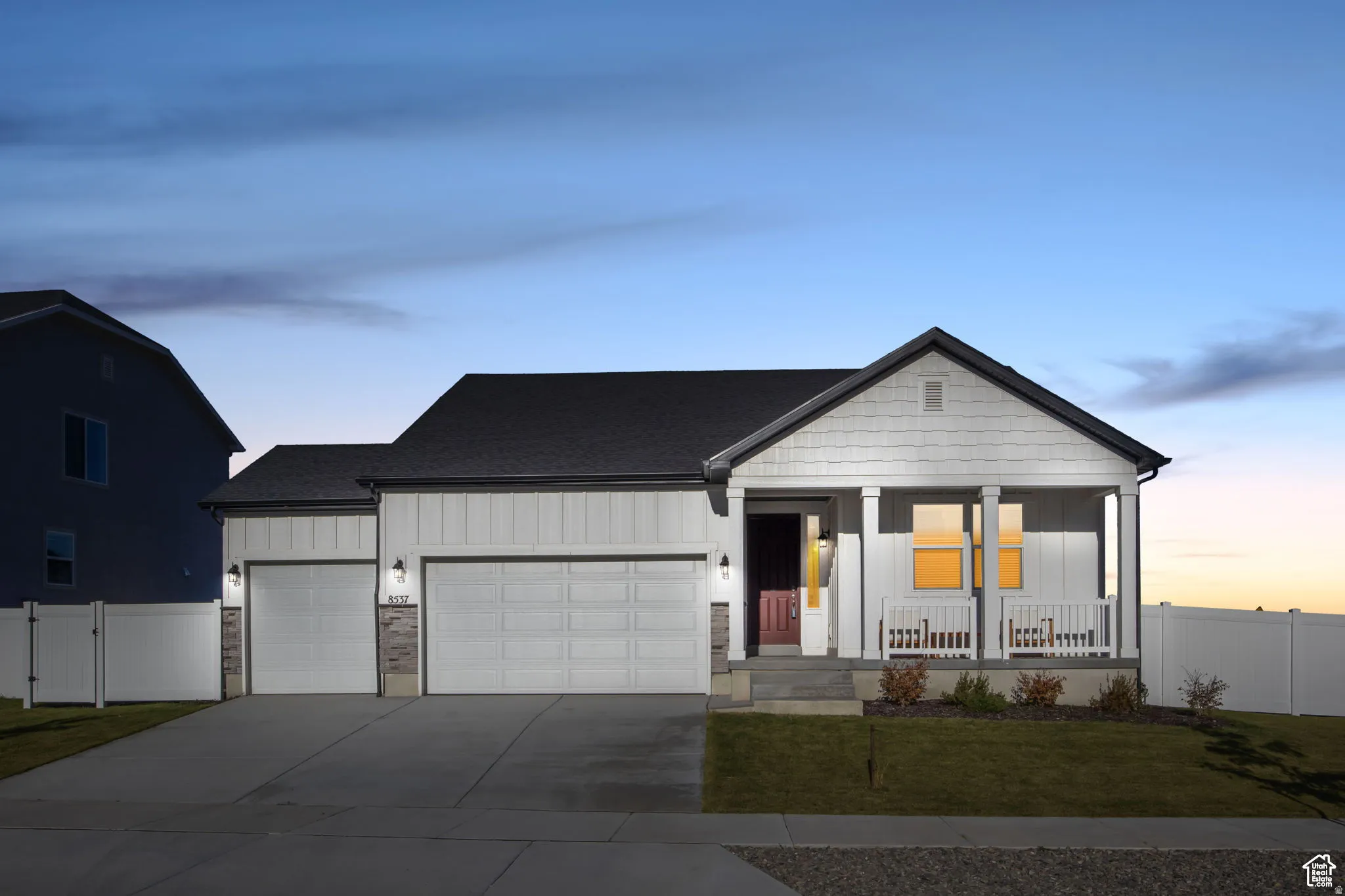 View of front of property with board and batten siding, a garage, covered porch, and driveway