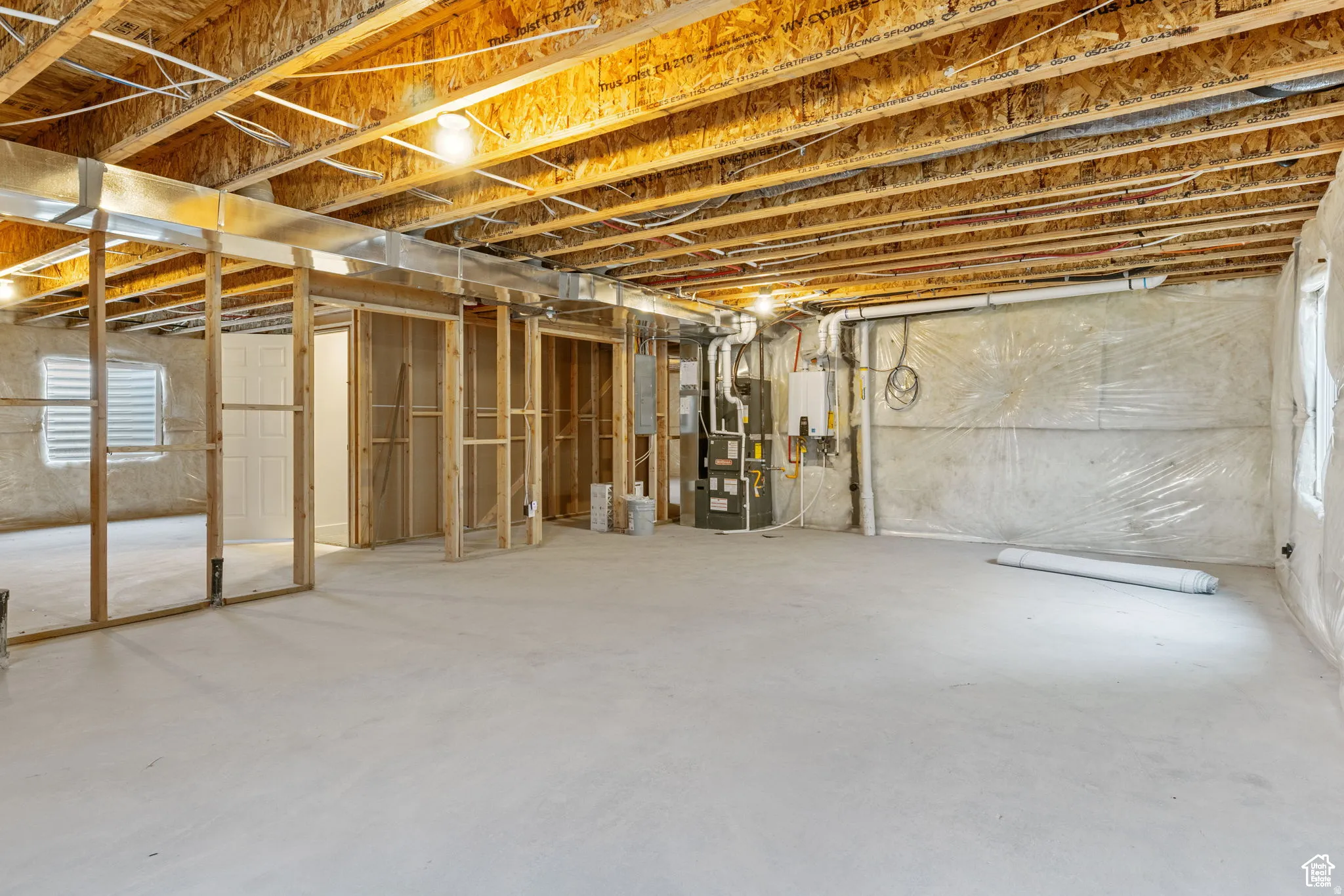 Basement featuring heating unit and water heater