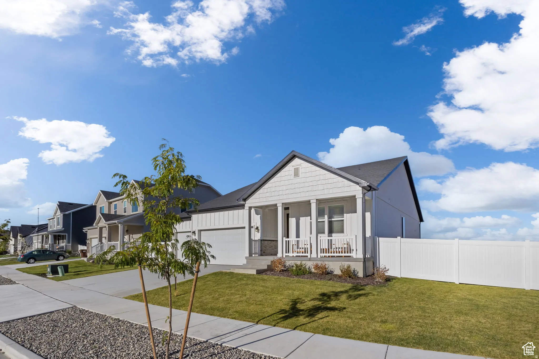 View of front of house featuring a porch, concrete driveway, board and batten siding, an attached garage, and stone siding