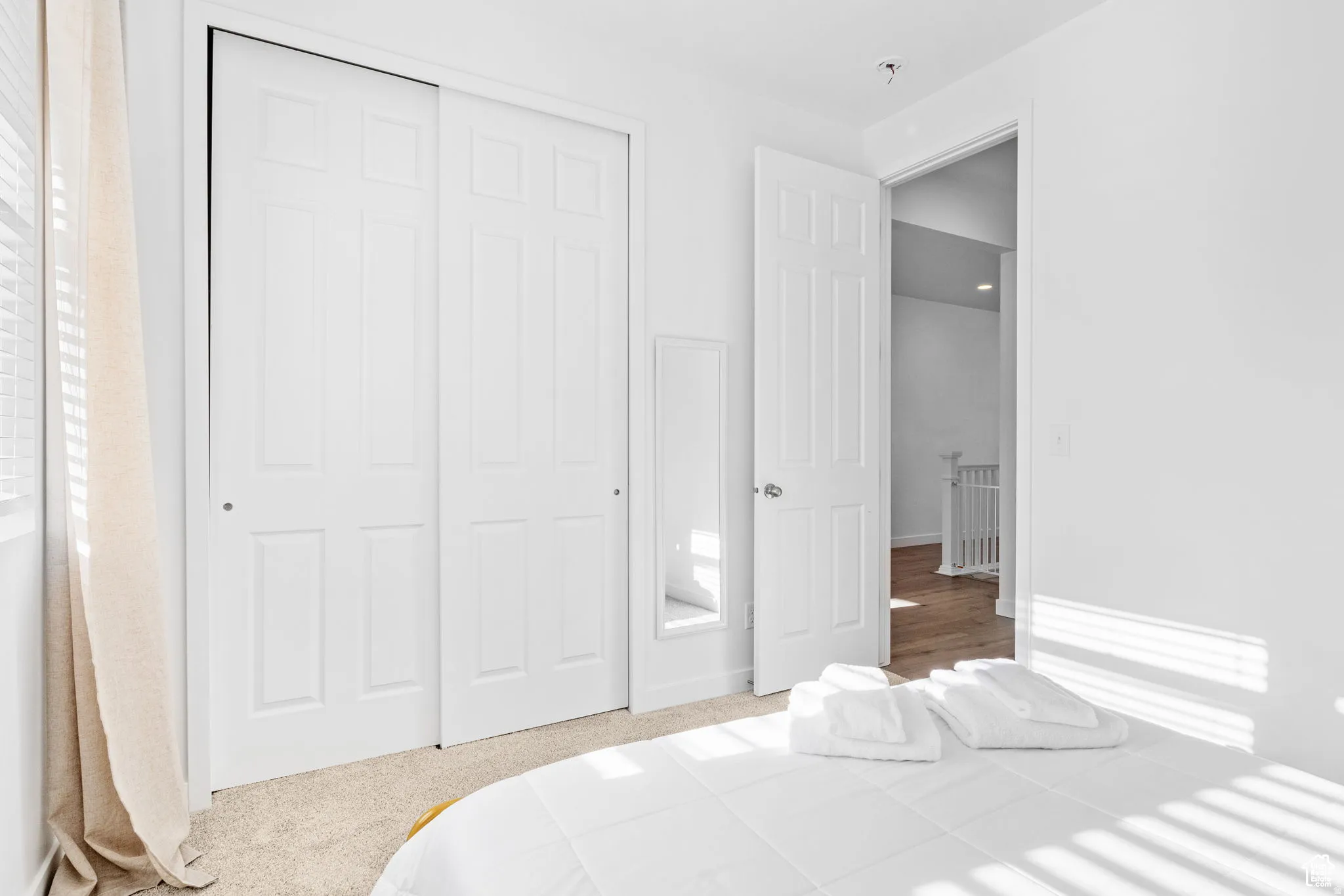 Bedroom with a closet and light colored carpet