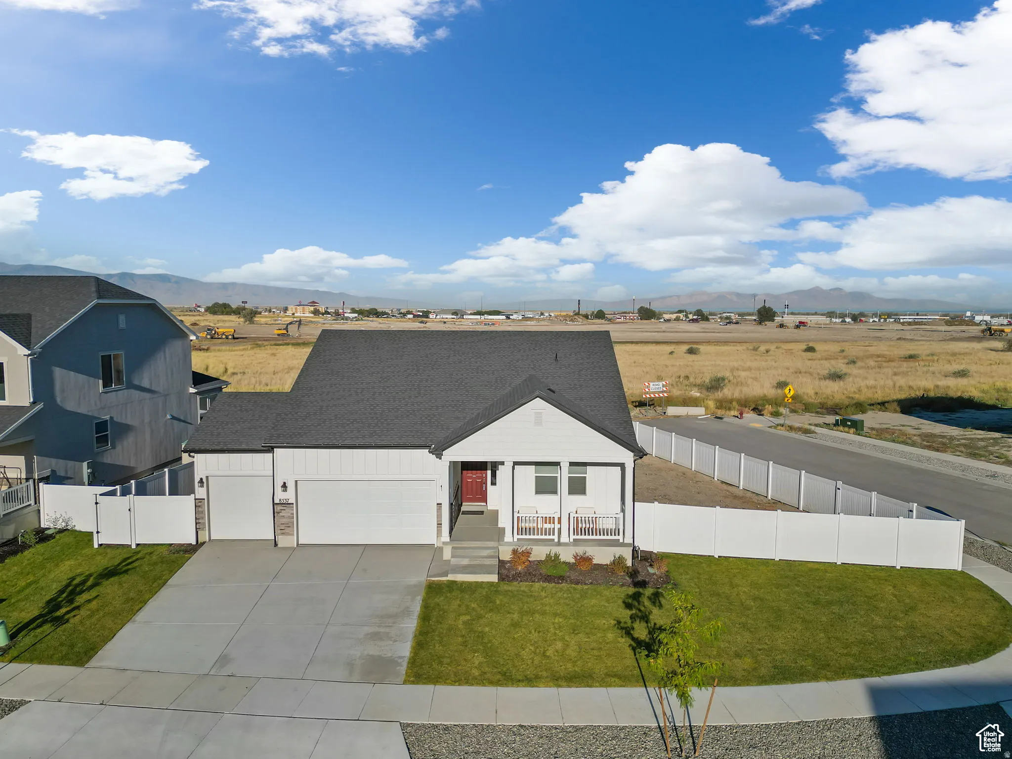 View of front of home featuring covered porch, an attached garage, driveway, and a mountain view