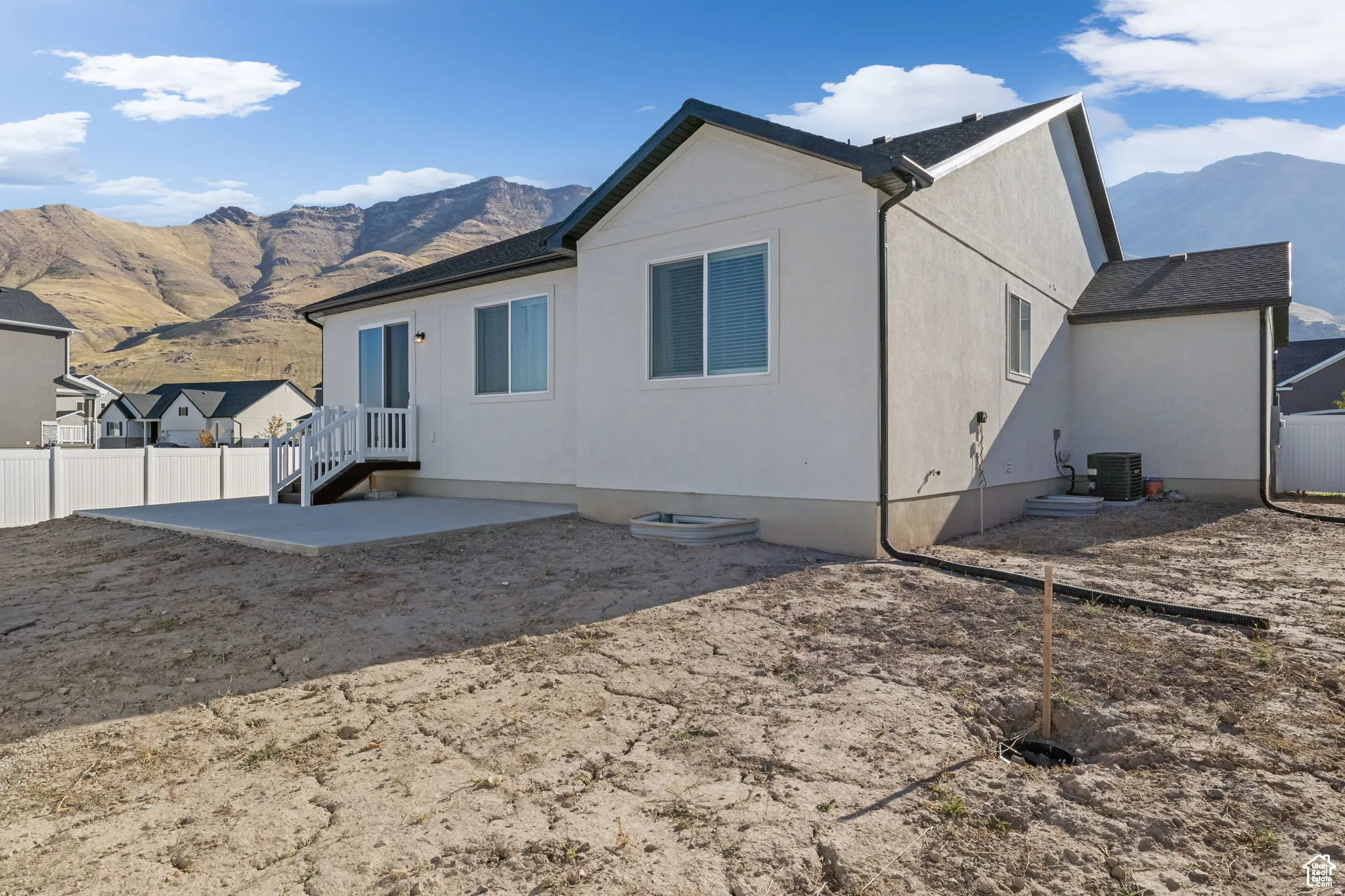 Rear view of house featuring a mountain view, a patio area, and stucco siding