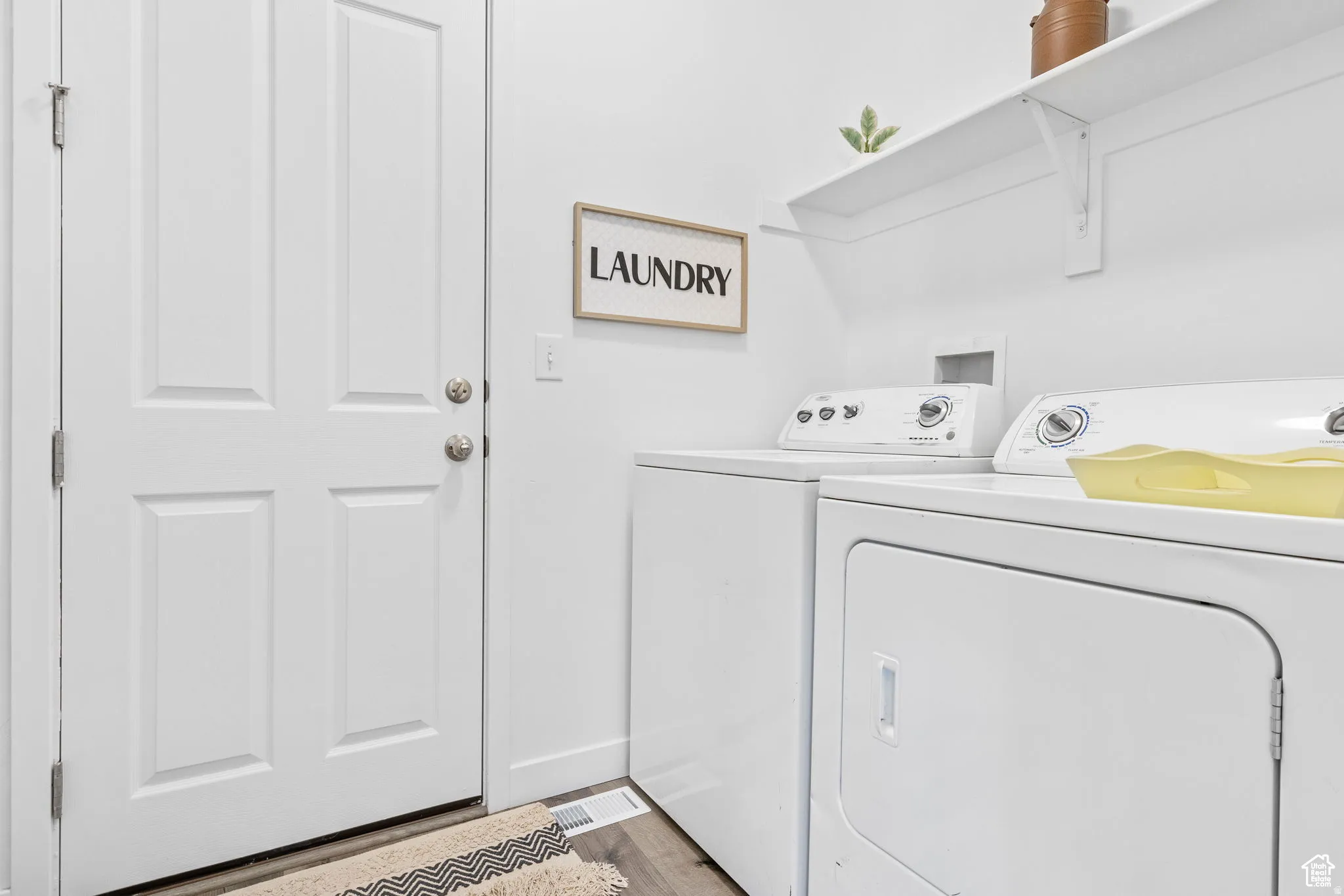 Laundry room featuring washing machine and dryer and light wood finished floors
