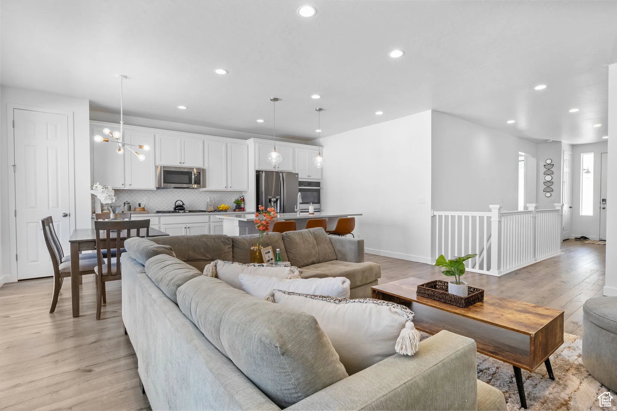 Living room featuring suspended lighting and light wood-style floors