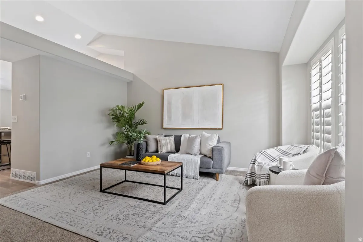 Living area featuring vaulted ceiling and baseboards