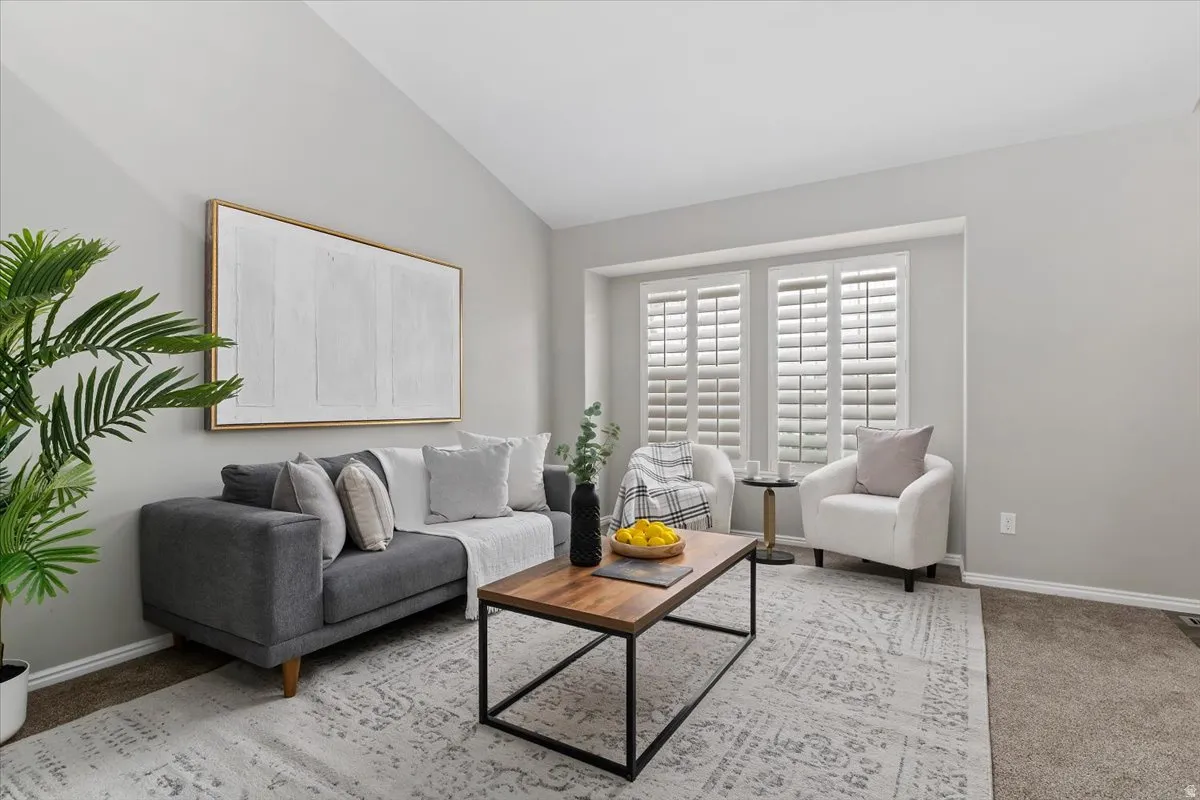 Living room with light colored carpet and lofted ceiling