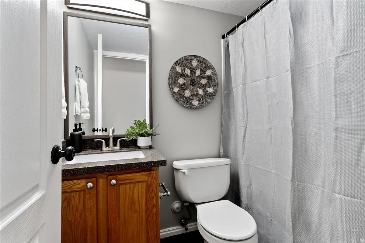 Bathroom featuring a shower with curtain and vanity