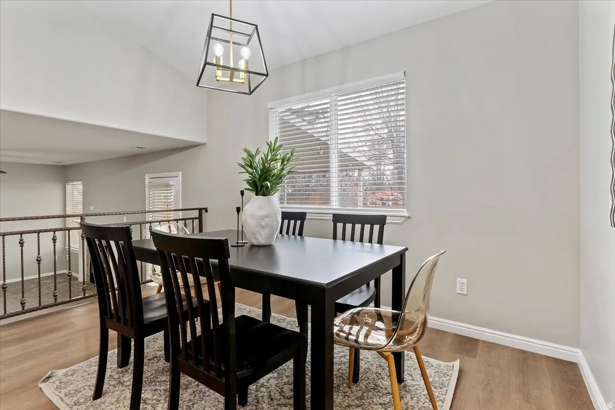 Dining room with light wood finished floors and hanging lights