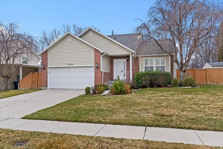 View of front of home with driveway, an attached garage, and brick siding