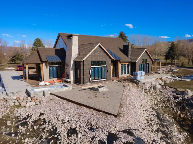 View of front facade featuring a patio, a chimney, and a standing seam roof